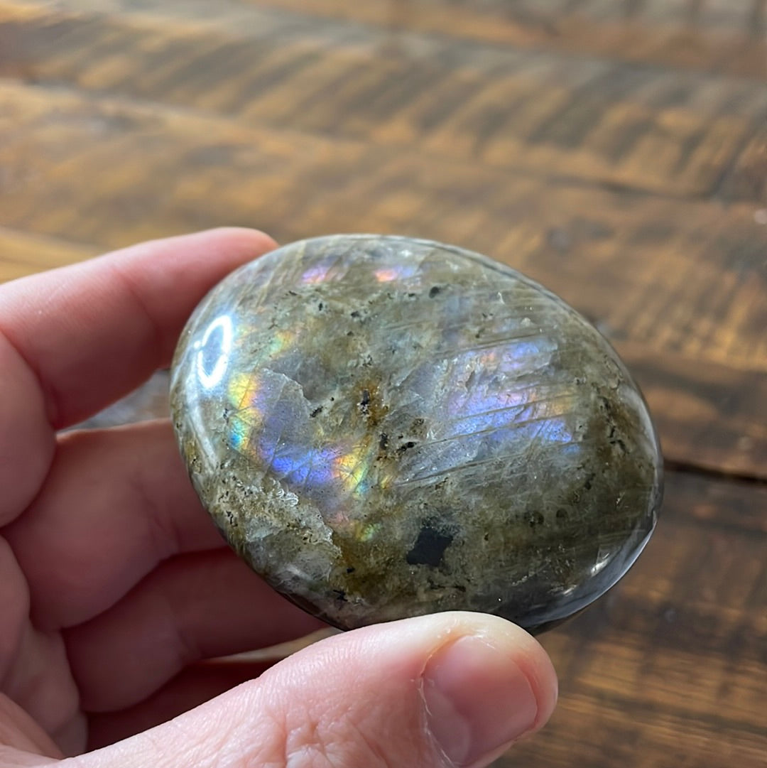 Labradorite palm stones featuring a captivating spectrum of pink, purple, green, gold and orange hues, enhanced by rainbow flashes for a unique vibrant crystal experience.