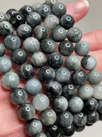 Hawk's Eye bracelet with 8mm beads, showcasing the mesmerizing blend of blue-grey hues in the hawk's eye gemstone. this bracelet combines unique aesthetics with subtle, earthy charm, making it a distinctive accessory.
