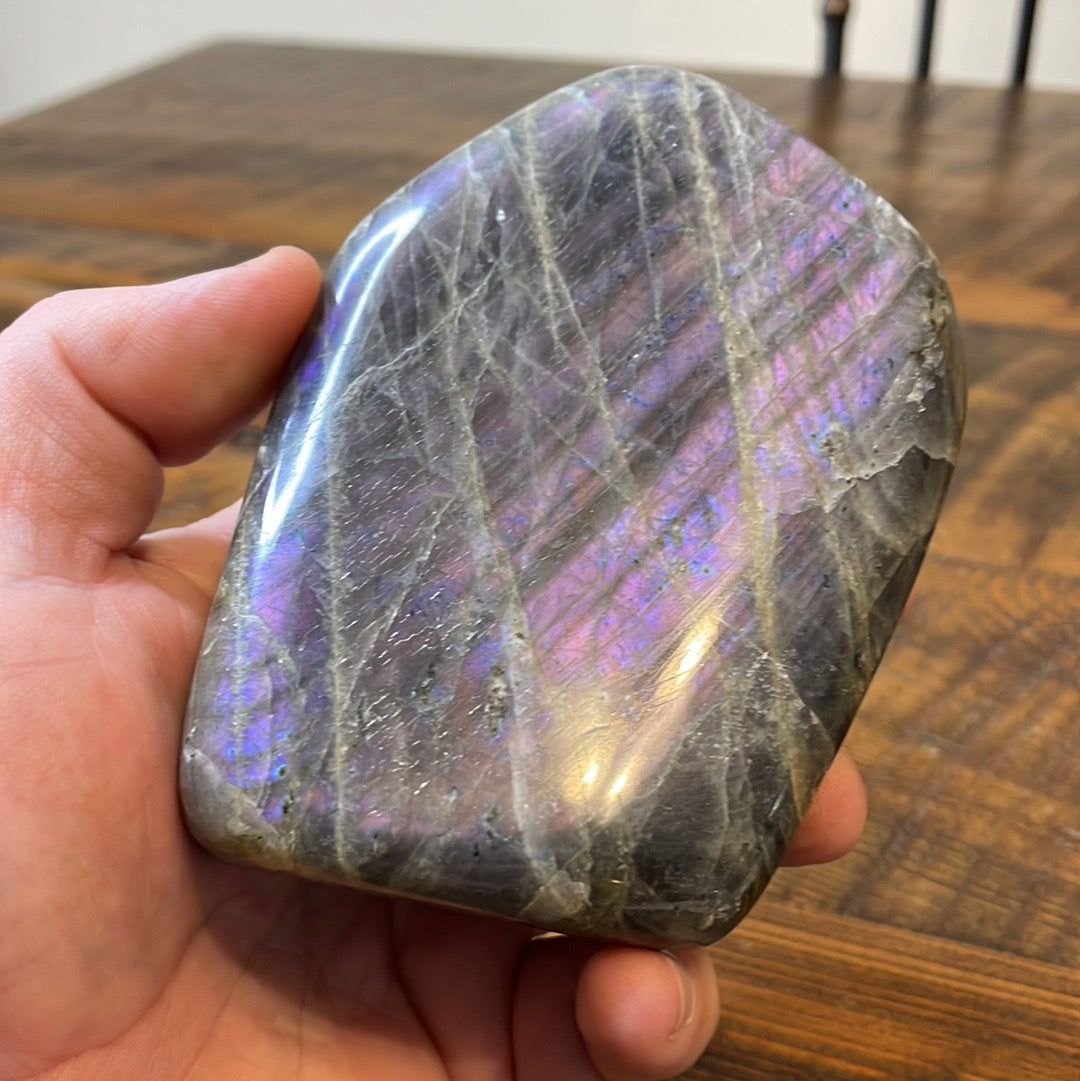 Labradorite free forms with a mesmerizing array of hues -pink, purple, green, gold,and orange, complemented by ethereal rainbow flashes, creating a vibrant enchanting crystal masterpiece.