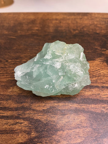 A raw Fluorite crystal in it's natural state, featuring a mix of translucent green and purple hues, reflecting the captivating beauty of this mineral's unique formations.