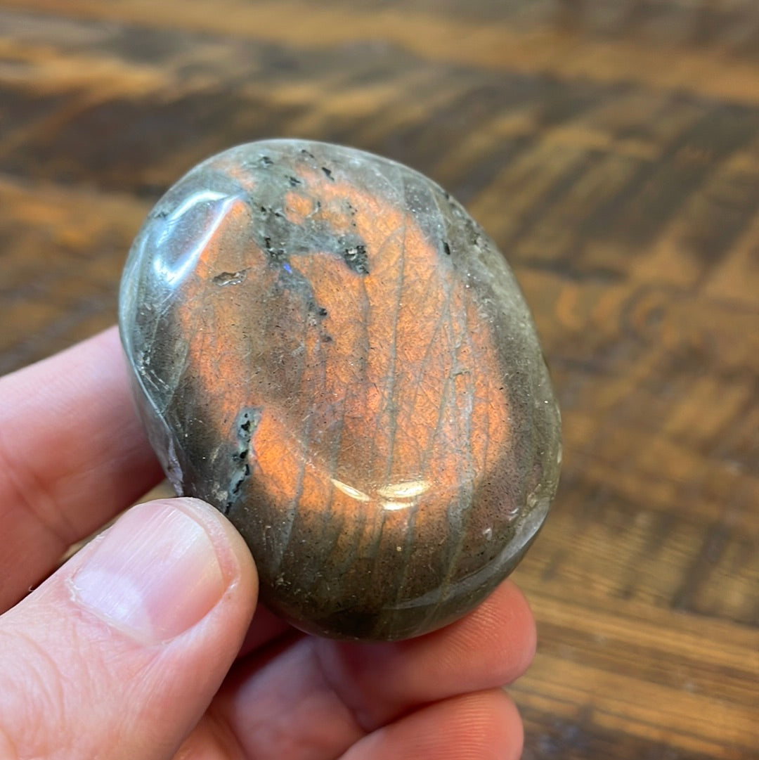 Labradorite palm stones featuring a captivating spectrum of pink, purple, green, gold and orange hues, enhanced by rainbow flashes for a unique vibrant crystal experience.