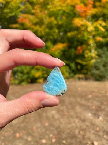 Super blue with soft white lines, tear drop in shape with polished surface. It has effects on four of the seven Chakras