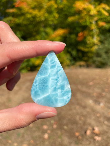 Super blue with soft white lines, tear drop in shape with polished surface. It has effects on four of the seven Chakras