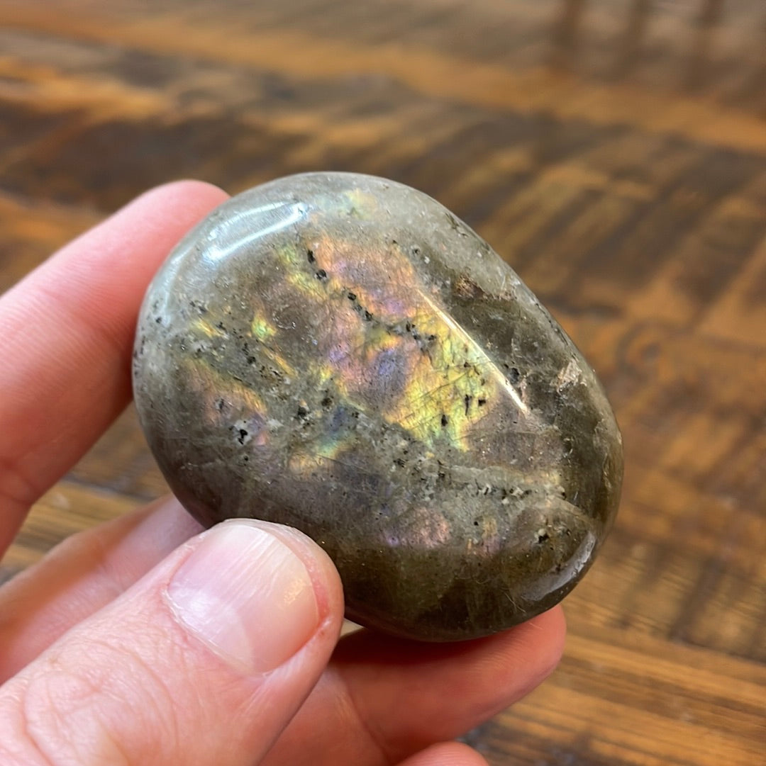 Labradorite palm stones featuring a captivating spectrum of pink, purple, green, gold and orange hues, enhanced by rainbow flashes for a unique vibrant crystal experience.