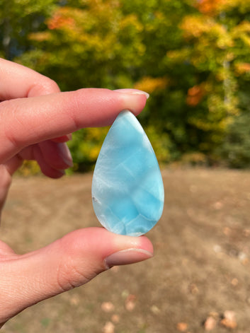 Super blue with soft white lines, tear drop in shape with polished surface. It has effects on four of the seven Chakras