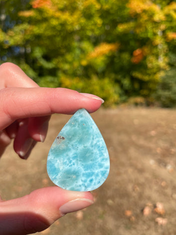 Light blue with soft white lines, Tear drop in shape, with polished surface. It has effects on four of the seven Chakras.