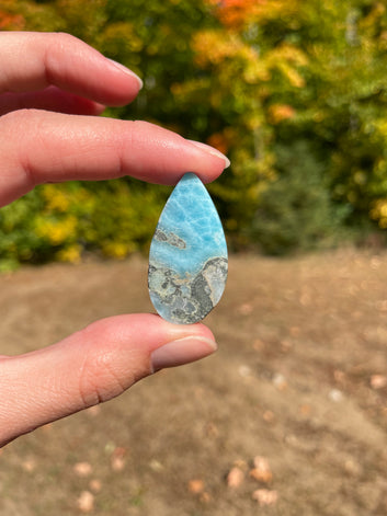 Deep blue with soft white lines. Oval in shape, with polished surface. It has effects on four of the seven Chakras.