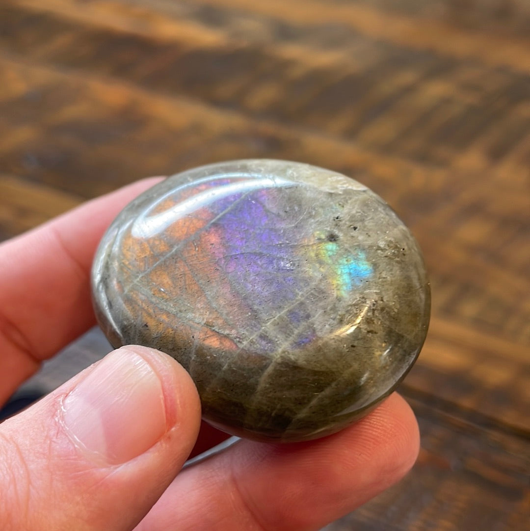 Labradorite palm stones featuring a captivating spectrum of pink, purple, green, gold and orange hues, enhanced by rainbow flashes for a unique vibrant crystal experience.