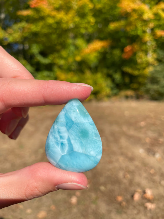 Light blue with soft white lines, Tear drop in shape, with polished surface. It has effects on four of the seven Chakras.