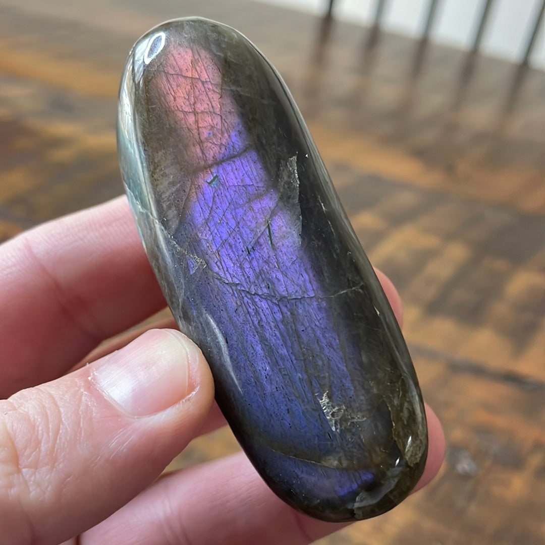 Labradorite palm stones featuring a captivating spectrum of pink, purple, green, gold and orange hues, enhanced by rainbow flashes for a unique vibrant crystal experience.