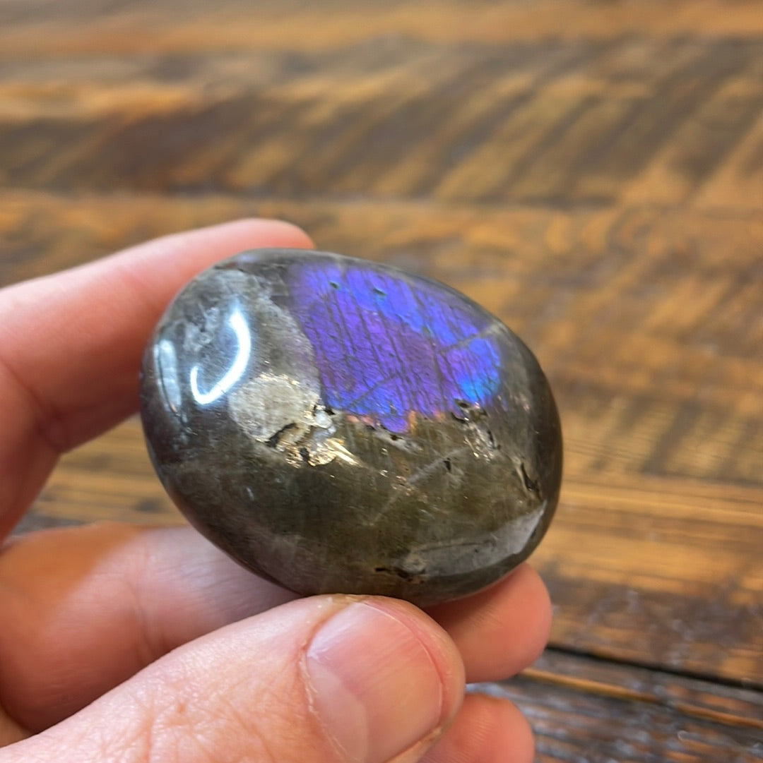 Labradorite palm stones featuring a captivating spectrum of pink, purple, green, gold and orange hues, enhanced by rainbow flashes for a unique vibrant crystal experience.