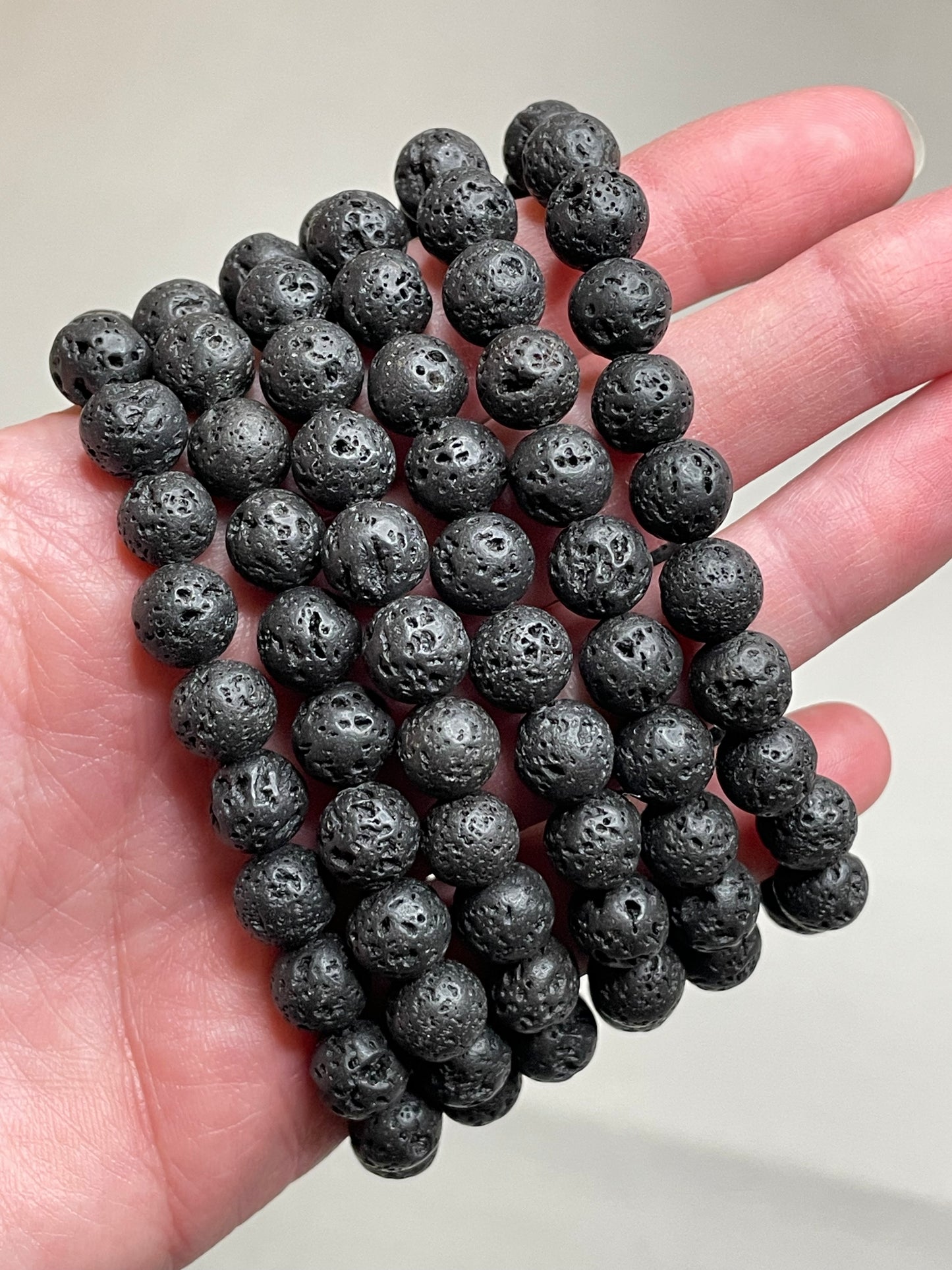 Black Lava stone bracelet with 8mm beads, showcasing the porous and textured surface of lava stones. This bracelet combines with sleek black aesthetic with the grounding properties of lava, making it a stylish and calming accessory.
