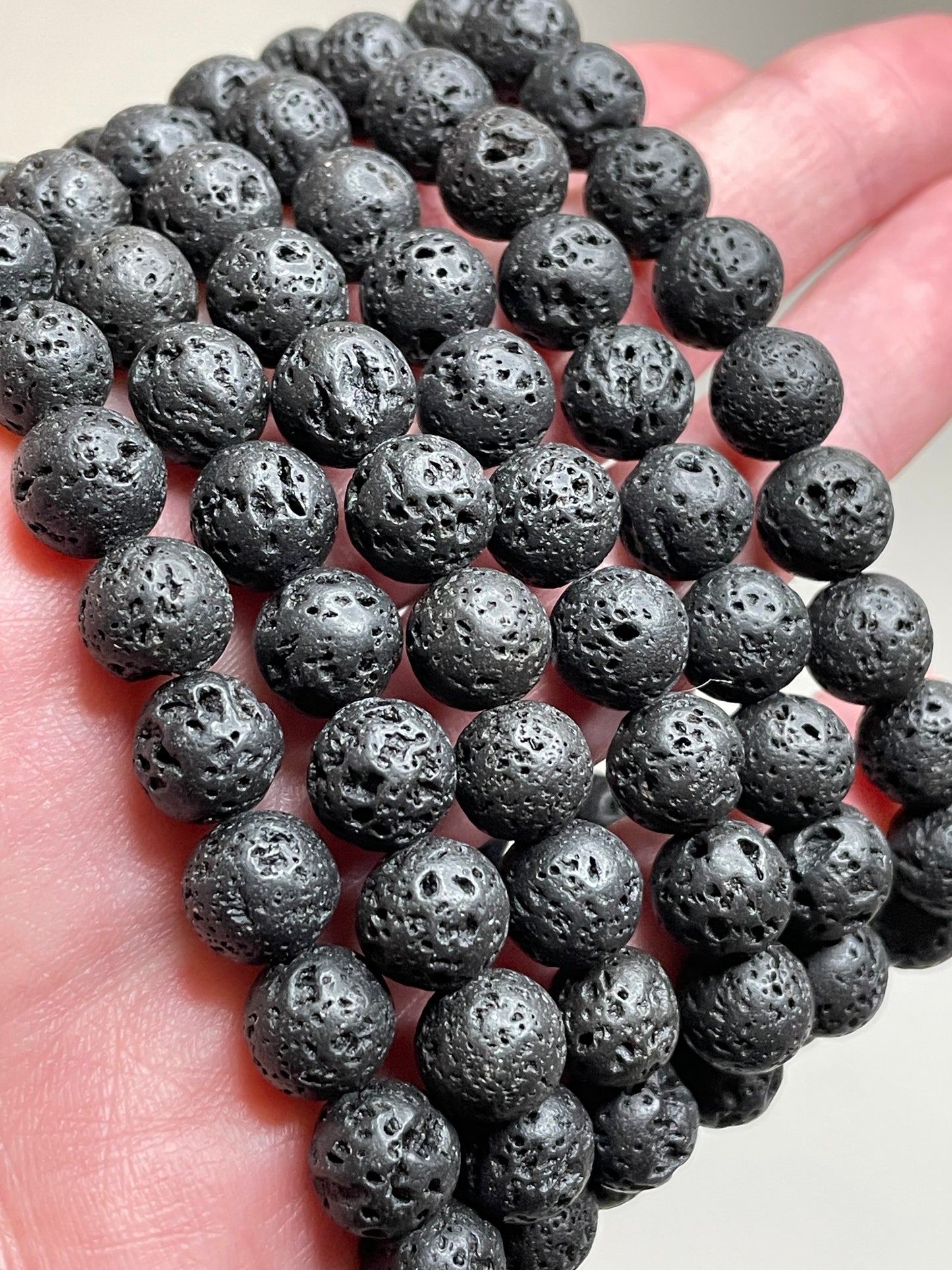 Black Lava stone bracelet with 8mm beads, showcasing the porous and textured surface of lava stones. This bracelet combines with sleek black aesthetic with the grounding properties of lava, making it a stylish and calming accessory.