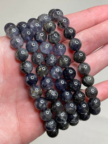 Lolite gemstone bracelet adorned with 8mm beads, displaying the mesmerizing violet-blue hues of Lolite crystals. This bracelet exudes a sense of sophistication and a touch of mystery, making it a captivating accessory for various occasions.