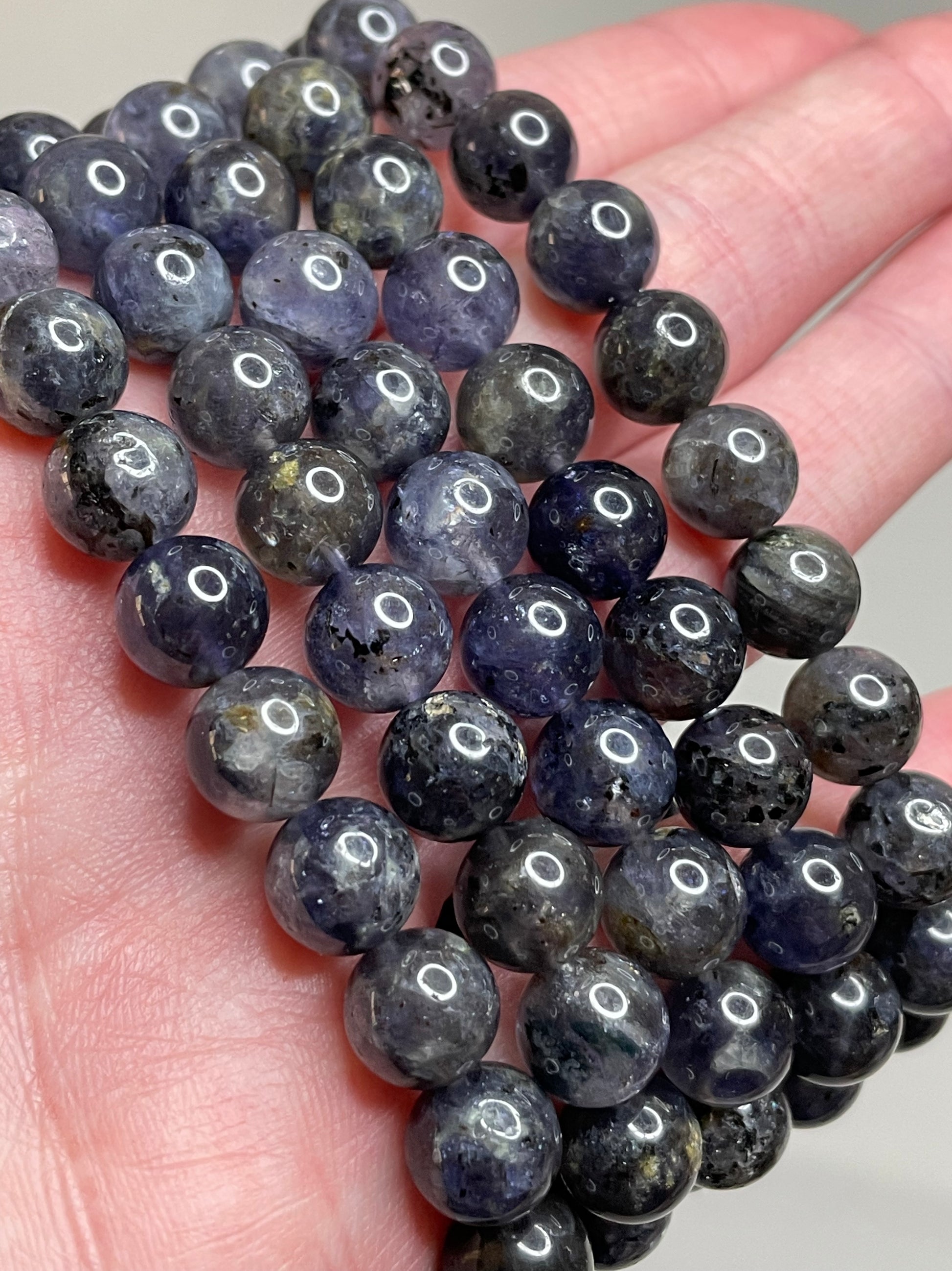 Lolite gemstone bracelet adorned with 8mm beads, displaying the mesmerizing violet-blue hues of Lolite crystals. This bracelet exudes a sense of sophistication and a touch of mystery, making it a captivating accessory for various occasions.