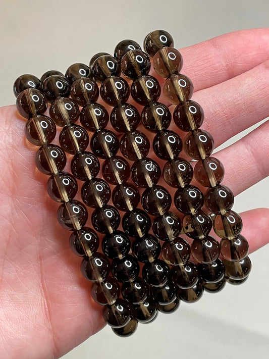Smokey Quartz bracelet with 8mm beads, showcasing the rich, smokey brown tones of Quartz crystals, radiating a sense of grounding and sophistication in this versatile and stylish accessory.