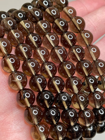 Smokey Quartz bracelet with 8mm beads, showcasing the rich, smokey brown tones of Quartz crystals, radiating a sense of grounding and sophistication in this versatile and stylish accessory.