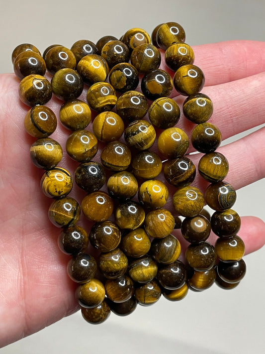 Tiger's eye 8mm bracelet, displaying the mesmerizing chatoyancy of golden and brown bands, radiating a sense of strength and confidence in this finely crafted and stylish accessory.