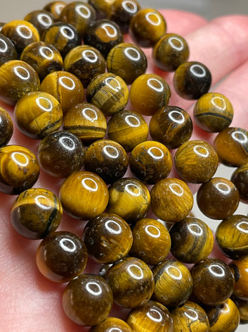 Tiger's eye 8mm bracelet, displaying the mesmerizing chatoyancy of golden and brown bands, radiating a sense of strength and confidence in this finely crafted and stylish accessory.