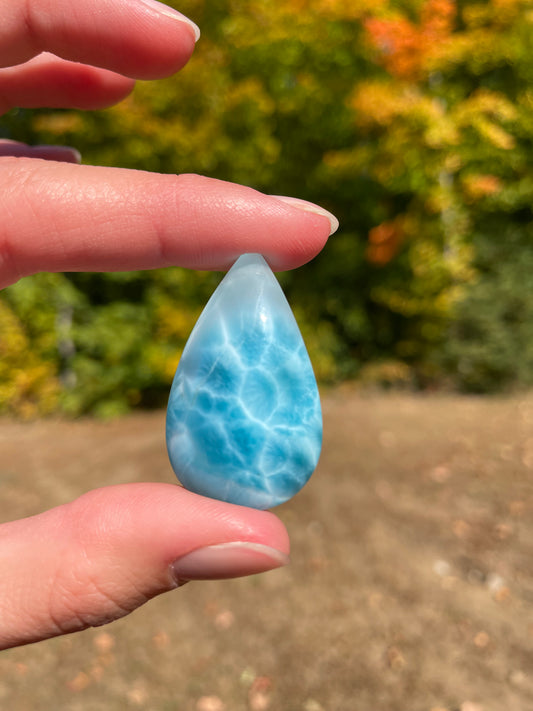 Super blue with soft white lines, tear drop in shape with polished surface. It has effects on four of the seven Chakras