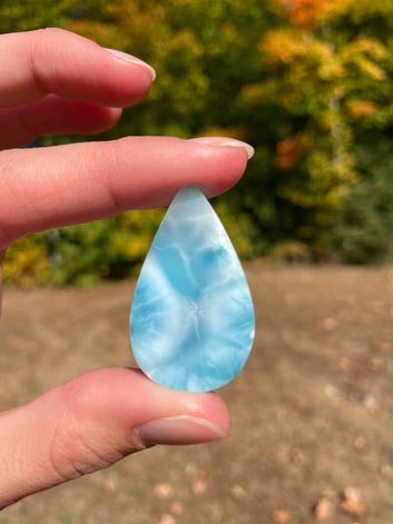 Super blue with soft white lines, tear drop in shape with polished surface. It has effects on four of the seven Chakras