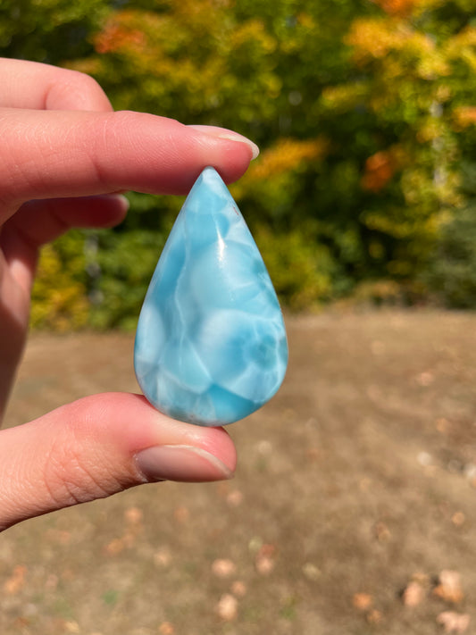 Light blue with soft white lines, Tear drop in shape, with polished surface. It has effects on four of the seven Chakras.