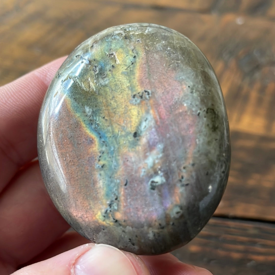 Labradorite palm stones featuring a captivating spectrum of pink, purple, green, gold and orange hues, enhanced by rainbow flashes for a unique vibrant crystal experience. 