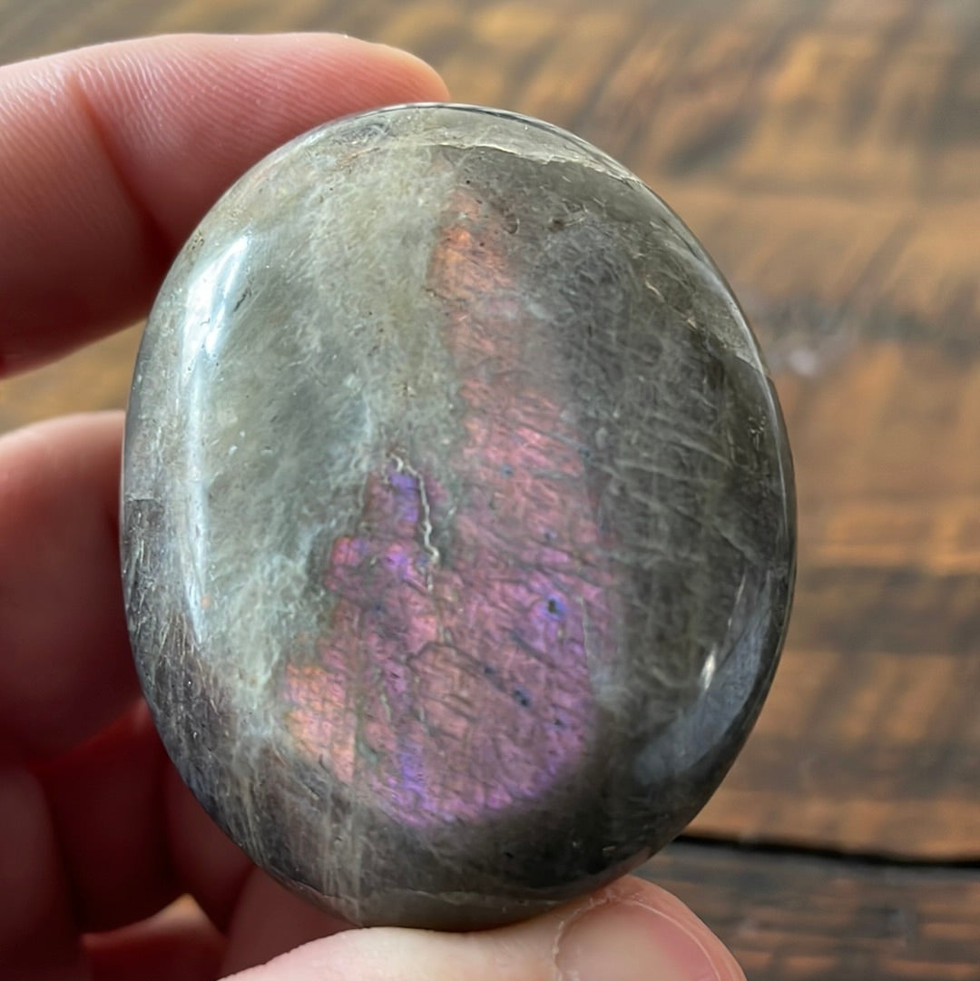 Labradorite palm stones featuring a captivating spectrum of pink, purple, green, gold and orange hues, enhanced by rainbow flashes for a unique vibrant crystal experience. 