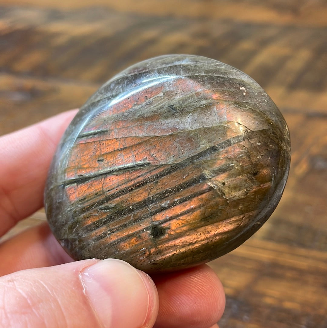 Labradorite palm stones featuring a captivating spectrum of pink, purple, green, gold and orange hues, enhanced by rainbow flashes for a unique vibrant crystal experience. 