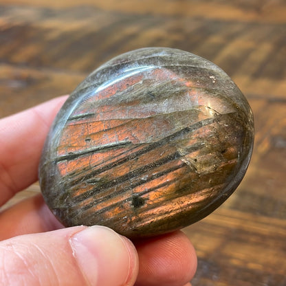 Labradorite palm stones featuring a captivating spectrum of pink, purple, green, gold and orange hues, enhanced by rainbow flashes for a unique vibrant crystal experience. 
