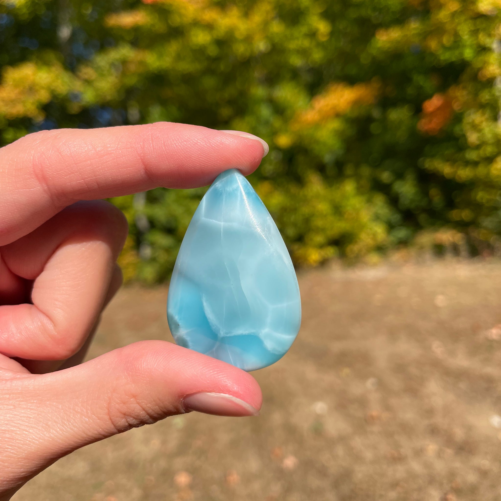 Light blue with soft white lines, Tear drop in shape, with polished surface. It has effects on four of the seven Chakras.