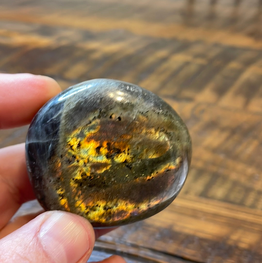Labradorite palm stones featuring a captivating spectrum of pink, purple, green, gold and orange hues, enhanced by rainbow flashes for a unique vibrant crystal experience. 