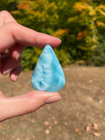 Super blue with soft white lines, tear drop in shape with polished surface. It has effects on four of the seven Chakras