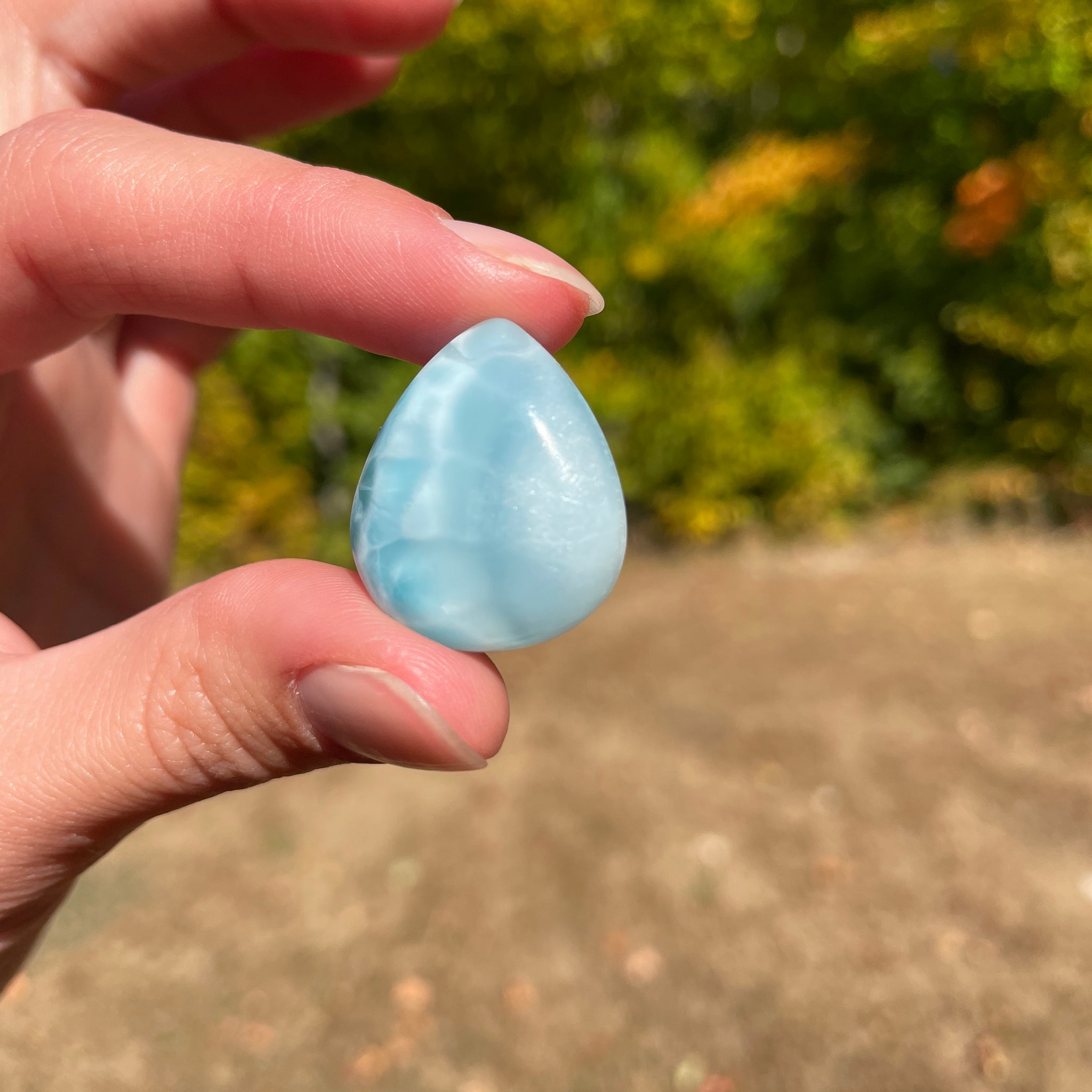 Light blue with soft white lines, Tear drop in shape, with polished surface. It has effects on four of the seven Chakras.
