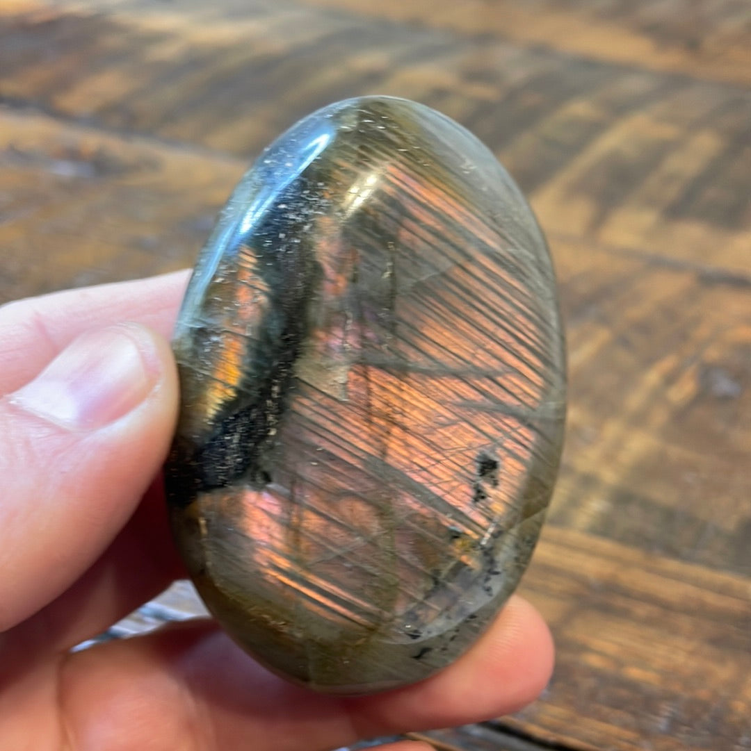 Labradorite palm stones featuring a captivating spectrum of pink, purple, green, gold and orange hues, enhanced by rainbow flashes for a unique vibrant crystal experience. 