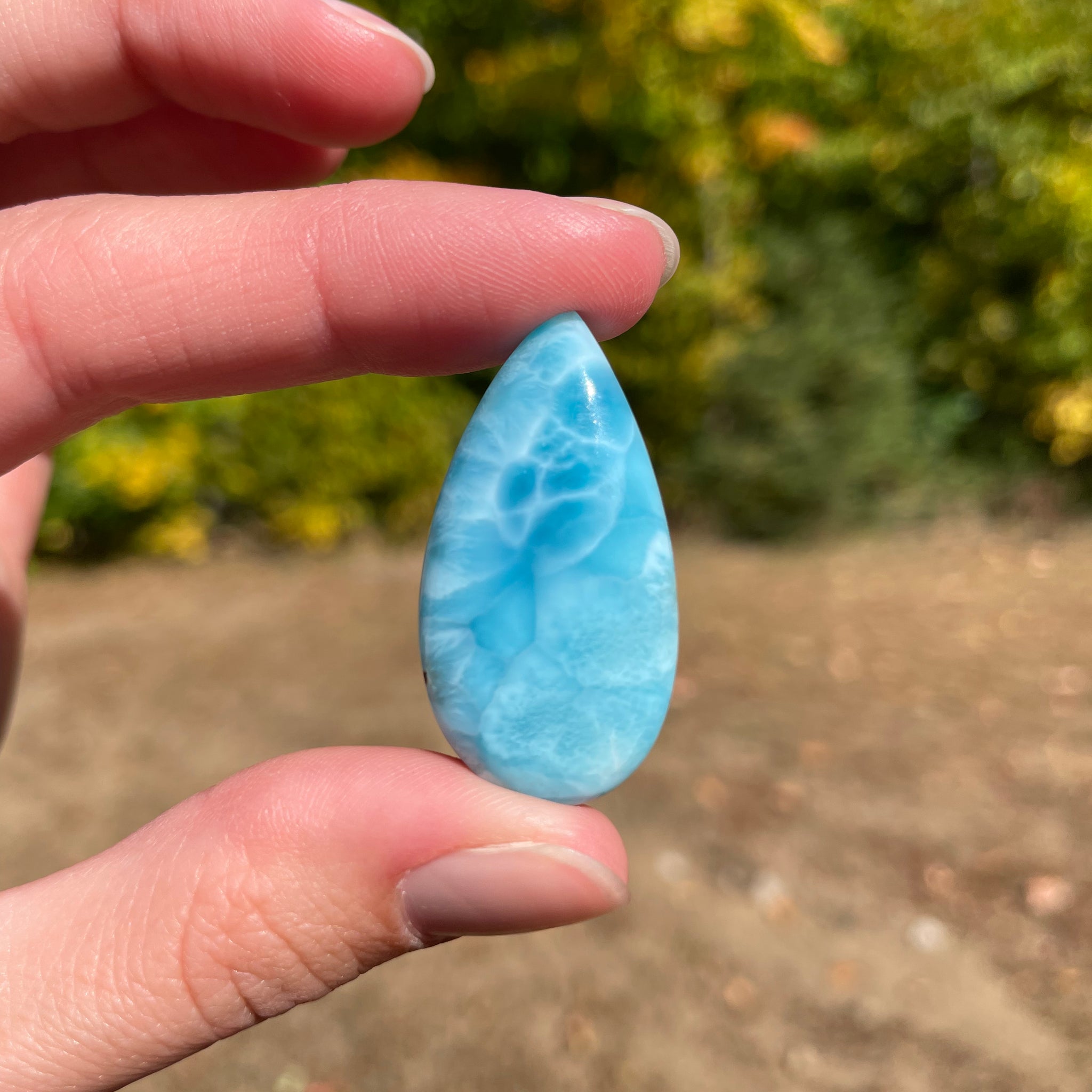 Deep blue with soft white lines. Oval in shape, with polished surface. It has effects on four of the seven Chakras.