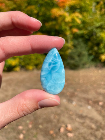 Deep blue with soft white lines. Oval in shape, with polished surface. It has effects on four of the seven Chakras.