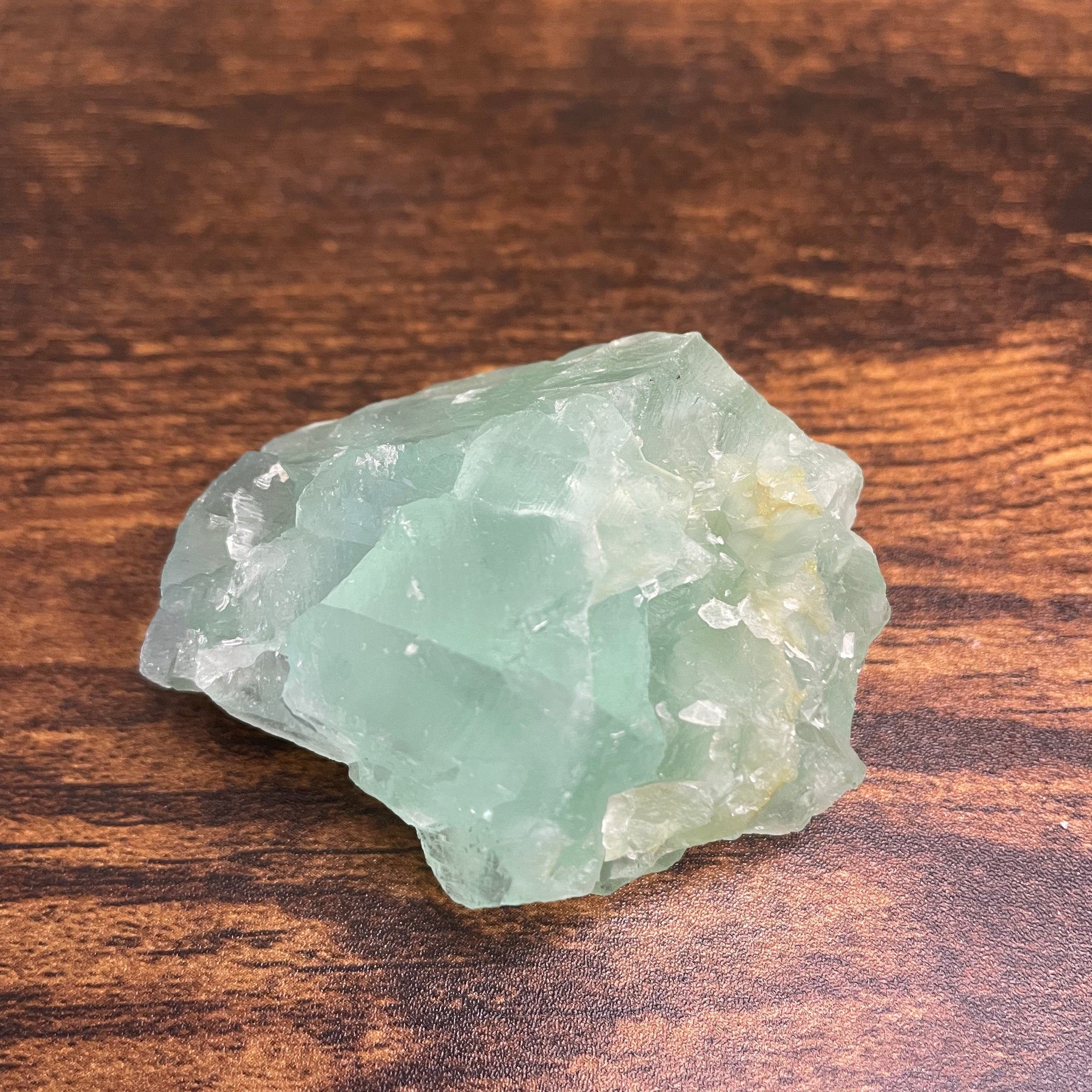 A raw Fluorite crystal in it's natural state, featuring a mix of translucent green and purple hues, reflecting the captivating beauty of this mineral's unique formations.