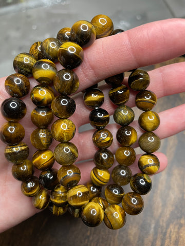 Tiger's eye 10mm bracelet, displaying the mesmerizing chatoyancy of golden and brown bands, radiating a sense of strength and confidence in this finely crafted and stylish accessory.