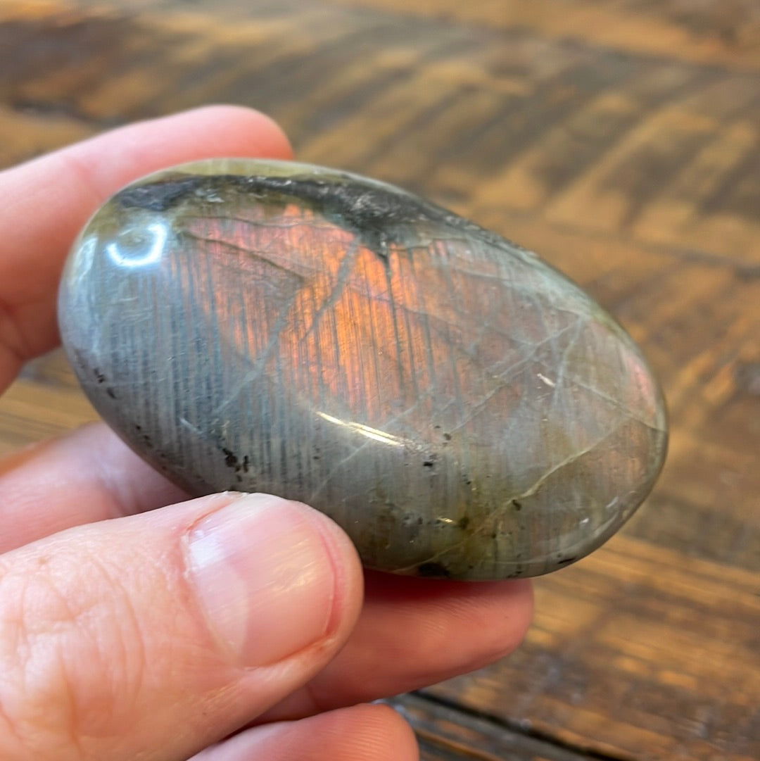 Labradorite palm stones featuring a captivating spectrum of pink, purple, green, gold and orange hues, enhanced by rainbow flashes for a unique vibrant crystal experience. 