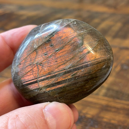 Labradorite palm stones featuring a captivating spectrum of pink, purple, green, gold and orange hues, enhanced by rainbow flashes for a unique vibrant crystal experience. 