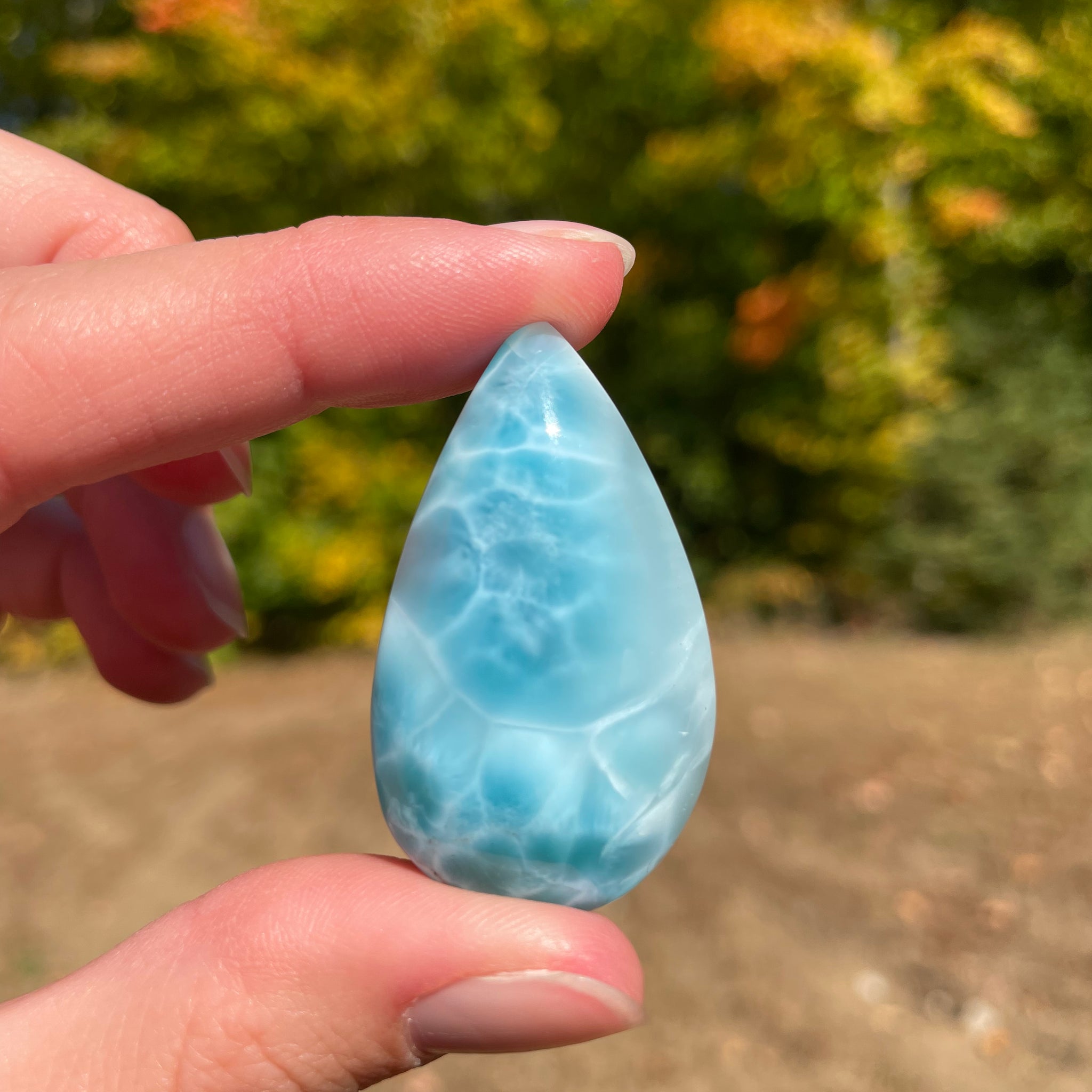 Super blue with soft white lines, tear drop in shape with polished surface. It has effects on four of the seven Chakras