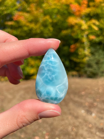 Super blue with soft white lines, tear drop in shape with polished surface. It has effects on four of the seven Chakras