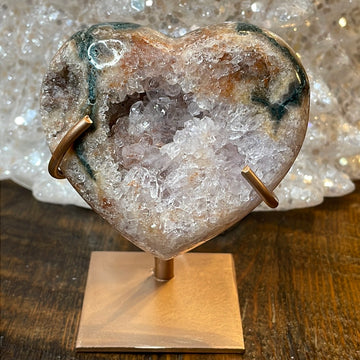 Pink Amethyst druzy hearts on custom metal stands, adorned with transparent crystals and a subtle hue of purple, creating a captivating fusion of elegance and enchantment.