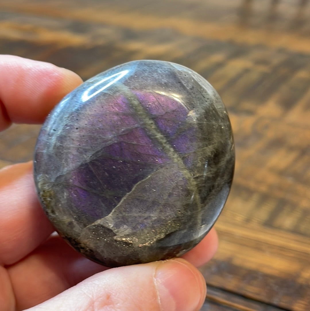 Labradorite palm stones featuring a captivating spectrum of pink, purple, green, gold and orange hues, enhanced by rainbow flashes for a unique vibrant crystal experience. 