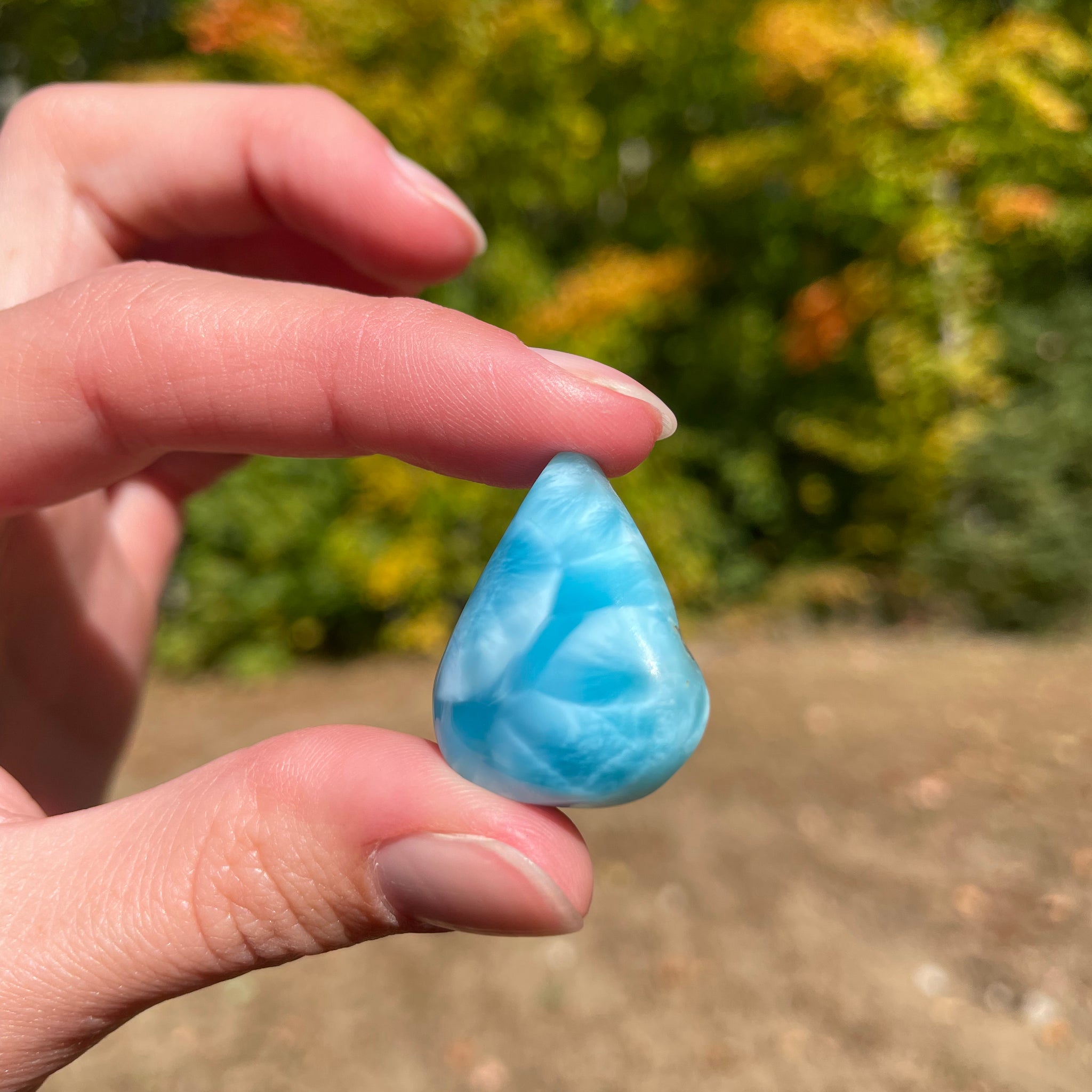 Super blue with soft white lines, tear drop in shape with polished surface. It has effects on four of the seven Chakras