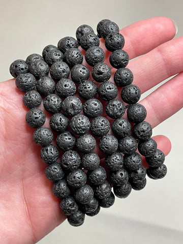 Black Lava stone bracelet with 8mm beads, showcasing the porous and textured surface of lava stones. This bracelet combines with sleek black aesthetic with the grounding properties of lava, making it a stylish and calming accessory. 