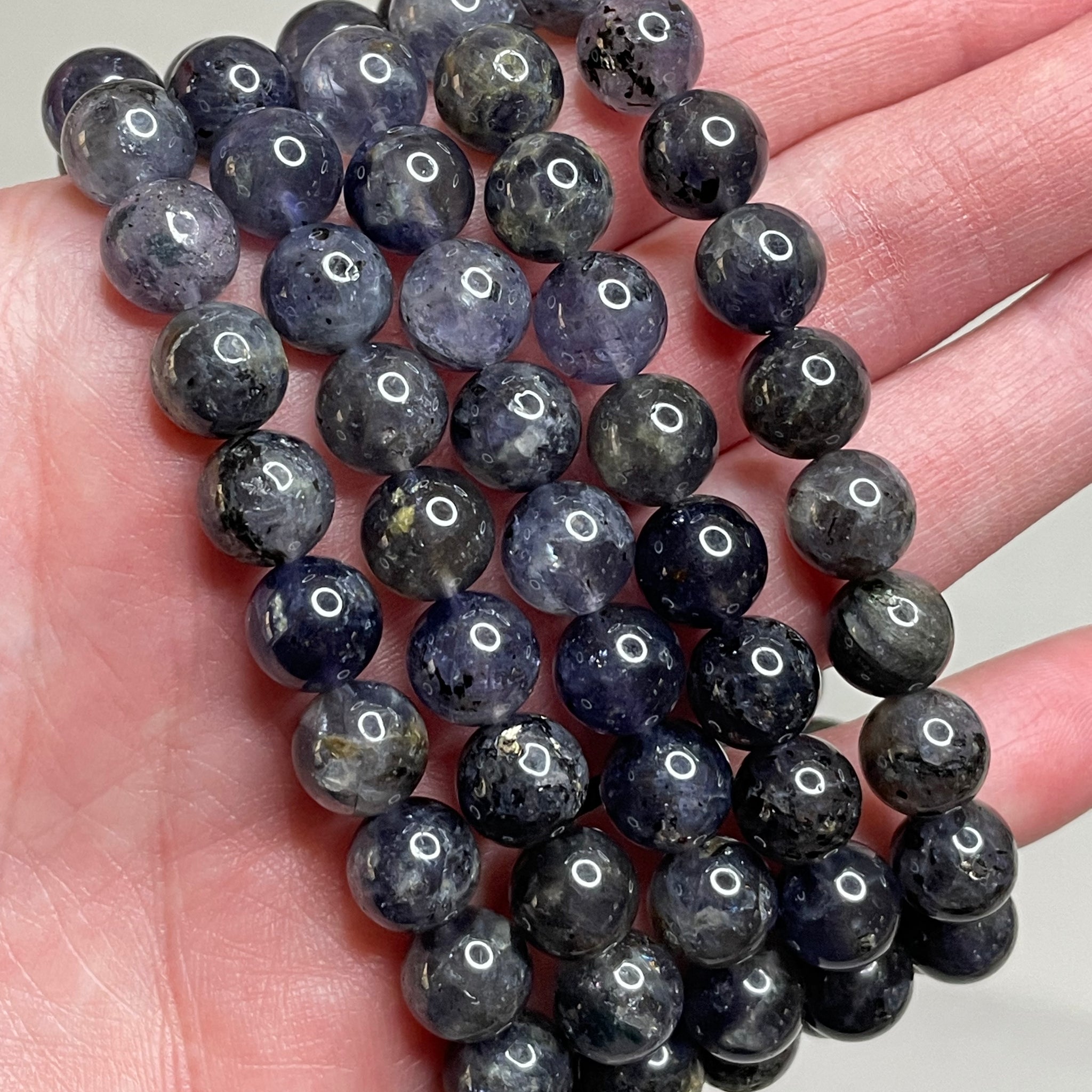 Lolite gemstone bracelet adorned with 8mm beads, displaying the mesmerizing violet-blue hues of Lolite crystals. This bracelet exudes a sense of sophistication and a touch of mystery, making it a captivating accessory for various occasions. 
