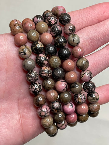 Rhodonite bracelet with 8mm beads, showcasing the harmonious blend of pink and black hues in the rhodonite gemstone. This bracelet exudes a sense balance and elegance, making it a charming accessory for various occasions. 