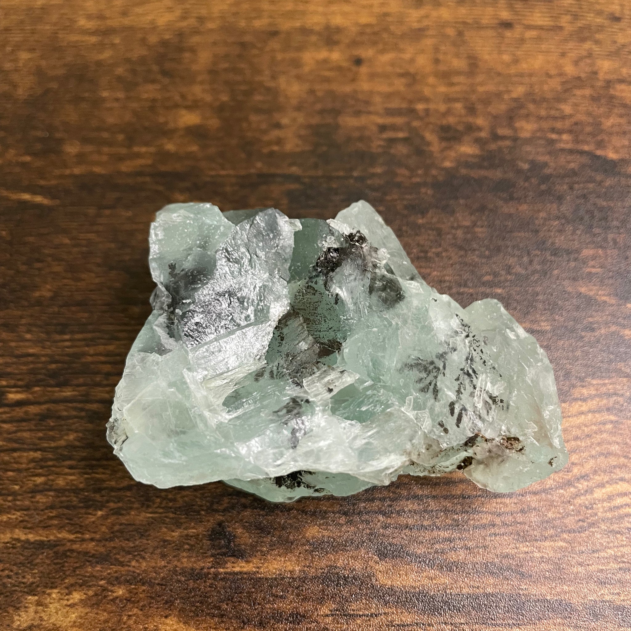 A raw Fluorite crystal in it's natural state, featuring a mix of translucent green and purple hues, reflecting the captivating beauty of this mineral's unique formations.